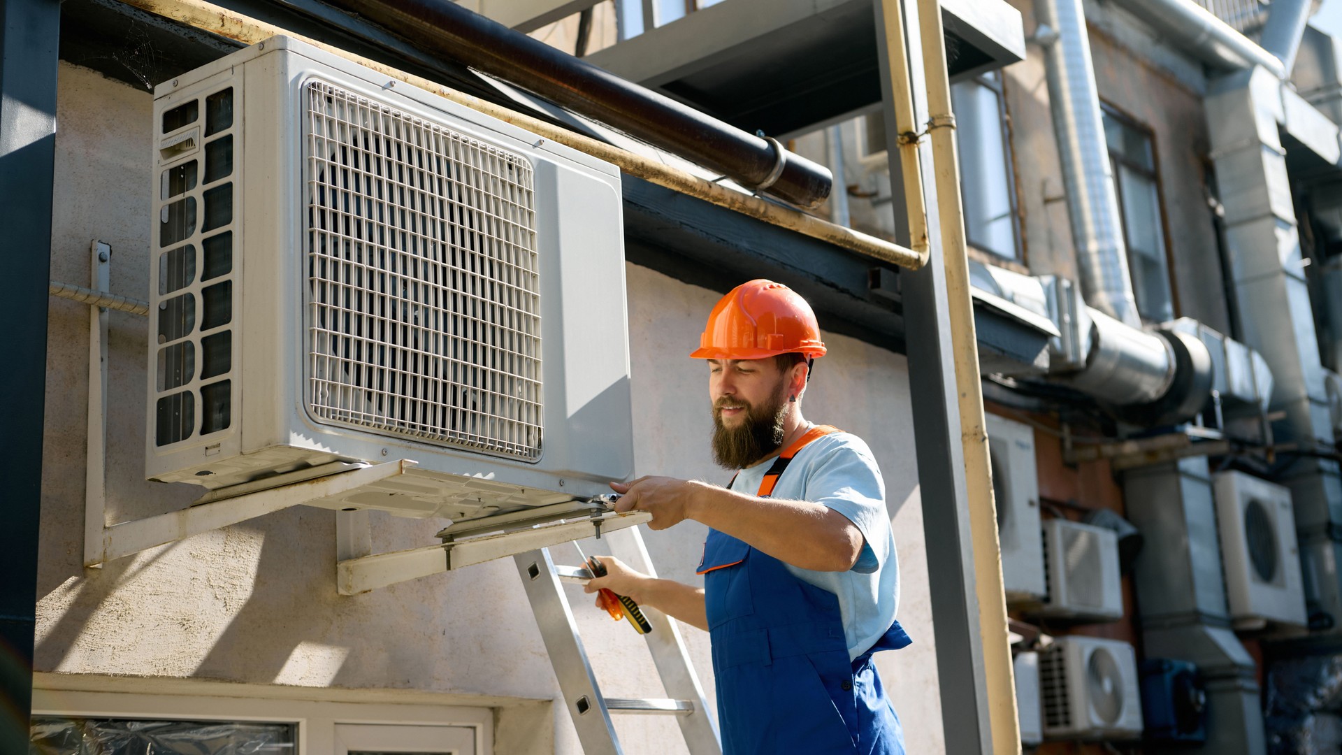 Technician installing air conditioning unit outdoors
